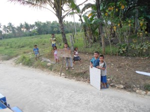 Kids along the road with help signs